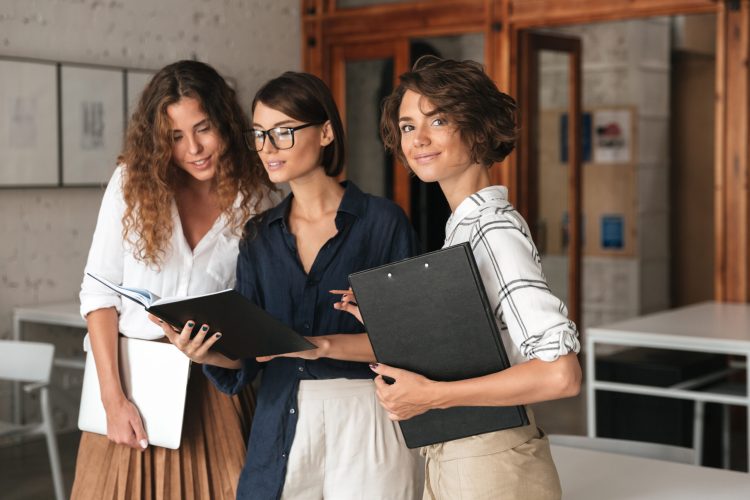 three business women in co working office three business women in co working office